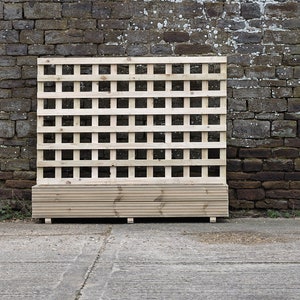 May include: A wooden trellis with a square grid pattern and a built-in planter box. The trellis is made of natural wood and is standing in front of a brick wall.
