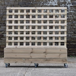 May include: A wooden planter box with a trellis on top. The planter box is on wheels and has a natural wood finish.