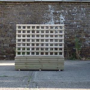 May include: A wooden planter with a lattice panel on the back. The planter is made of natural wood and has a rustic look.