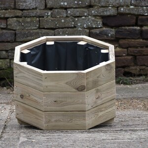 May include: Octagonal wooden planter with a black liner. The planter is made of natural wood and has a rustic look.