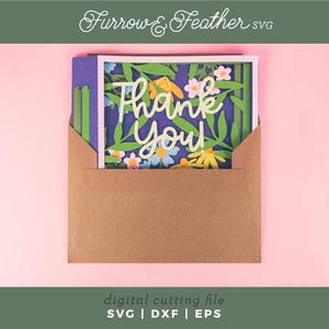 May include: A floral "Thank You" card in a brown envelope. The card features a white frame with a blue background, green leaves, and colorful flowers. The words "Thank You" are in a cursive font. The image also includes the text "Furrow & Feather SVG" and "digital cutting file SVG | DXF | EPS".