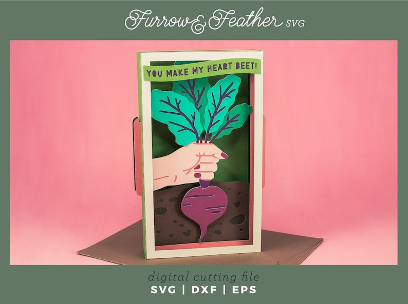May include: A digital cutting file for a card featuring a hand holding a beet with the text "YOU MAKE MY HEART BEET!" in a green and white frame.