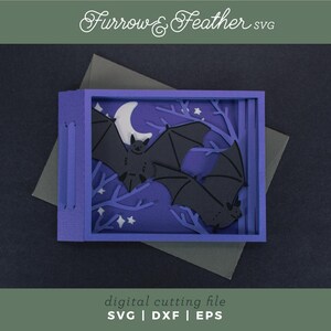 Pode incluir: Uma pe&ccedil;a de arte em papel em camadas com uma cena noturna com morcegos, uma lua crescente e estrelas. A obra de arte est&aacute; em uma moldura roxa com o texto "Furrow & Feather SVG" e "digital cutting file SVG | DXF | EPS".