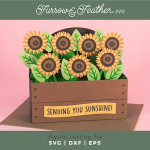 May include: A papercraft of sunflowers in a brown wooden crate, with green leaves and yellow petals. The crate has a yellow banner that reads "SENDING YOU SUNSHINE!". The image is a digital cutting file.