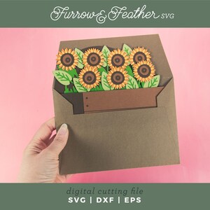 May include: A brown paper envelope contains a bouquet of sunflowers with green leaves. The sunflowers have yellow petals and brown centres. The text "Furrow & Feather SVG" is at the top. The bottom text reads "digital cutting file SVG | DXF | EPS".