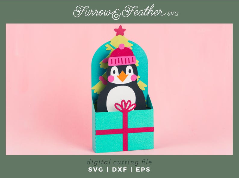 May include: A teal gift box with a red ribbon and a penguin wearing a pink hat peeking out of the top. The penguin is surrounded by green and yellow paper cutouts of a Christmas tree.