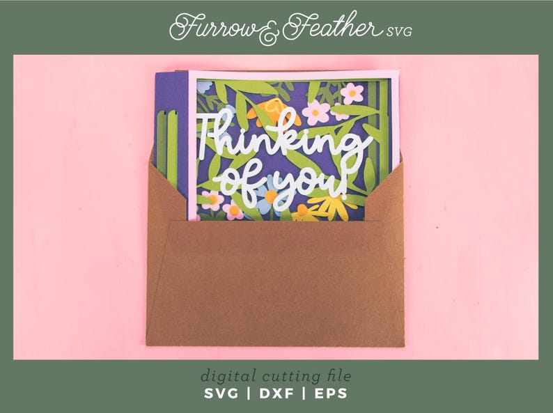 May include: A paper card with the words "Thinking of you" in white script, surrounded by a floral design, is partially inserted into a brown envelope. The card is set against a purple background with green leaves and colorful flowers. The image includes the text "Furrow & Feather SVG" and "digital cutting file SVG | DXF | EPS".