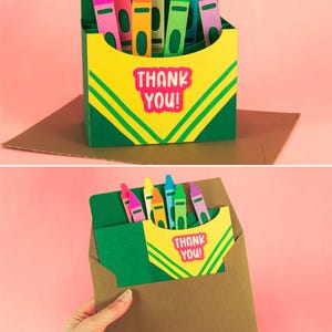 May include: A green and yellow box with a pop-up card inside. The box has a row of colorful crayons sticking out of the top. The card says "Thank You!" in pink letters.