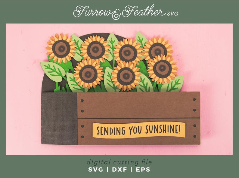 May include: A papercraft of sunflowers in a brown wooden crate with green leaves. The sunflowers have yellow petals and brown centres. The crate has the text "SENDING YOU SUNSHINE!" on a yellow banner. The image has the text "Furrow & Feather SVG".