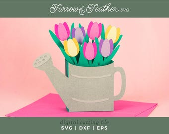 Puede incluir: Un diseño de archivo de corte digital de una regadera gris con asa, llena de un ramo de tulipanes rosas, morados y amarillos. El texto "Furrow & Feather SVG" está en la parte superior de la imagen. El texto "digital cutting file SVG | DXF | EPS" está en la parte inferior de la imagen.