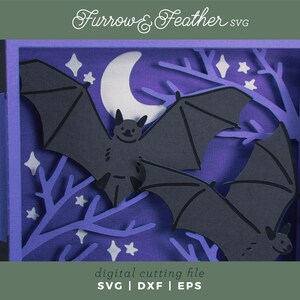 Pode incluir: Uma pe&ccedil;a de arte em papel em camadas com uma cena noturna com dois morcegos pretos, uma lua crescente e estrelas em um fundo roxo. A obra de arte &eacute; emoldurada em uma borda roxa, com o texto "Furrow & Feather SVG" no topo.