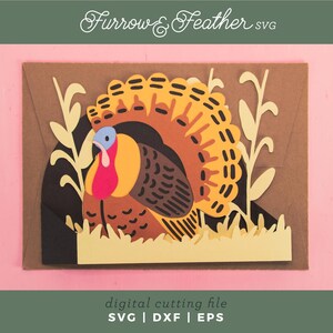 May include: A colorful paper cut-out of a turkey with a yellow, orange, and brown tail, a blue head, and a red wattle. The turkey is set against a brown background with yellow grass and foliage. The text "Furrow & Feather SVG" and "digital cutting file" are also present.