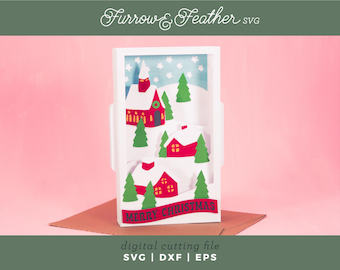 May include: A white card with a pop-up winter village scene. The scene features a red church with a green wreath on the door, a red house with white trim, and green trees. The card reads "Merry Christmas".