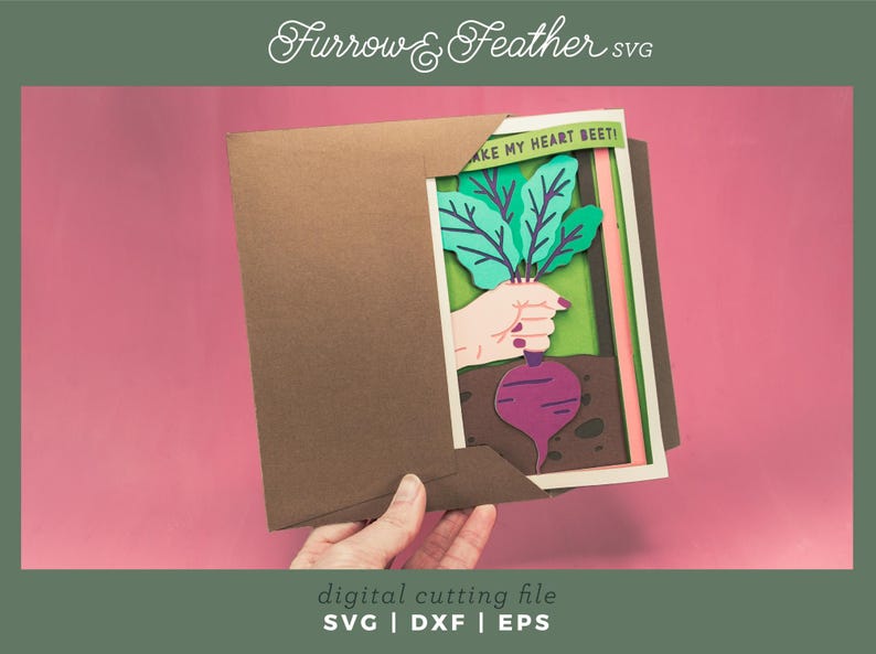 May include: A paper craft card with a layered design of a hand holding a beet with green leaves. The card has the text "Take my heart beet!" on it.