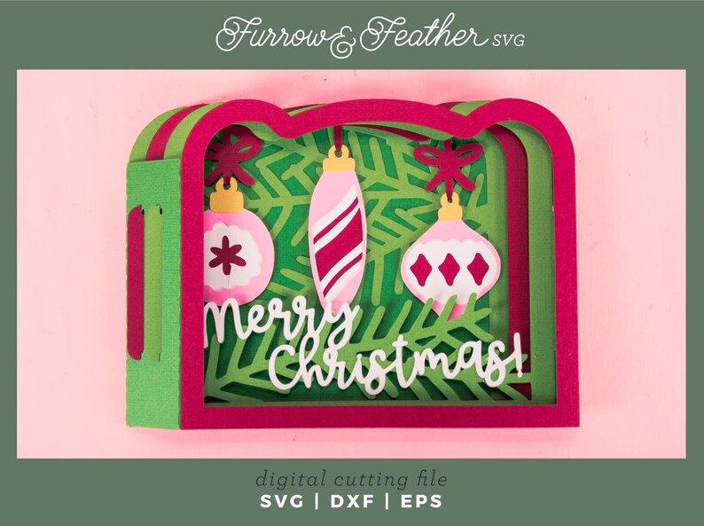 May include: A layered Christmas-themed papercraft design with pink, green, and red accents. The design features three hanging ornaments and the words "Merry Christmas!" in white. The image is a digital cutting file.
