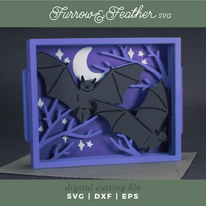 Pode incluir: Uma pe&ccedil;a de arte em papel em camadas com tema de Halloween. O design inclui morcegos pretos, uma lua crescente, estrelas e galhos, tudo em um fundo roxo dentro de uma moldura azul. O texto "Furrow & Feather SVG" e "digital cutting file" tamb&eacute;m &eacute; vis&iacute;vel.