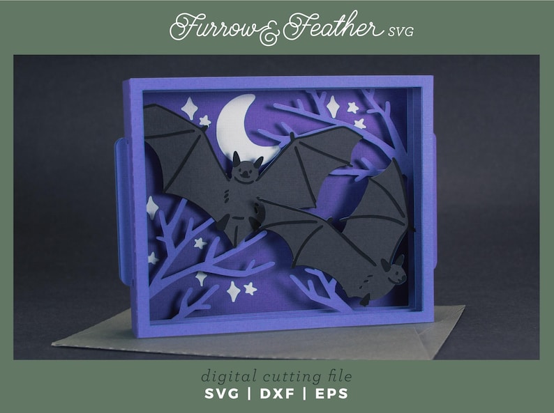 Pode incluir: Uma pe&ccedil;a de arte em papel em camadas com tema de Halloween. O design inclui morcegos pretos, uma lua crescente, estrelas e galhos, tudo em um fundo roxo dentro de uma moldura azul. O texto "Furrow & Feather SVG" e "digital cutting file" tamb&eacute;m &eacute; vis&iacute;vel.