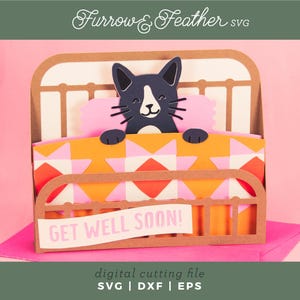 Puede incluir: Tarjeta de manualidades de papel con un gato blanco y negro en una cama con una almohada rosa y una manta estampada naranja y blanca. La tarjeta dice "GET WELL SOON!". La tarjeta es un archivo de corte digital.