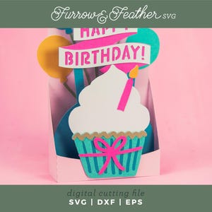 May include: A digital cutting file for a birthday card featuring a cupcake with a pink bow and the words "Happy Birthday!" in a banner.
