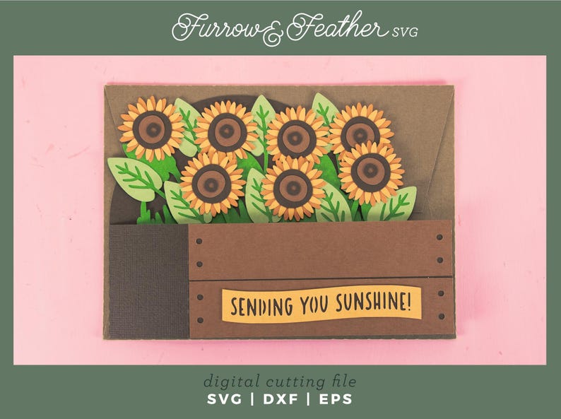 May include: A papercraft greeting card with sunflowers in a wooden crate. The sunflowers have yellow petals and brown centres, with green leaves. The card includes the text "SENDING YOU SUNSHINE!" and "Furrow & Feather SVG".