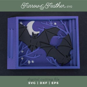 Pode incluir: Uma pe&ccedil;a de arte em papel em camadas com tema de Halloween. A obra apresenta morcegos pretos, uma lua crescente branca e estrelas em um fundo azul escuro. A pe&ccedil;a &eacute; emoldurada em uma caixa roxa, com o texto "Furrow & Feather SVG" no topo.