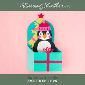 May include: A teal gift box with a pink ribbon and a penguin wearing a pink hat peeking out of the top. The penguin is standing in front of a green Christmas tree with yellow lights. The background is pink.