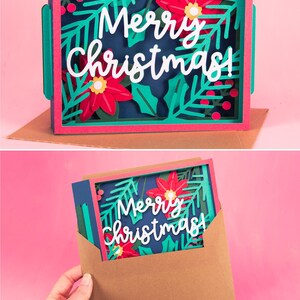 Może przedstawiać: Wielowarstwowa kartka świąteczna o świątecznym designie. Kartka ma ciemnoniebieskie tło z białym napisem "Merry Christmas!" otoczonym czerwonymi gwiazdami betlejemskimi, zielonymi liśćmi i czerwonymi jagodami. Kartka jest w brązowej kopercie.