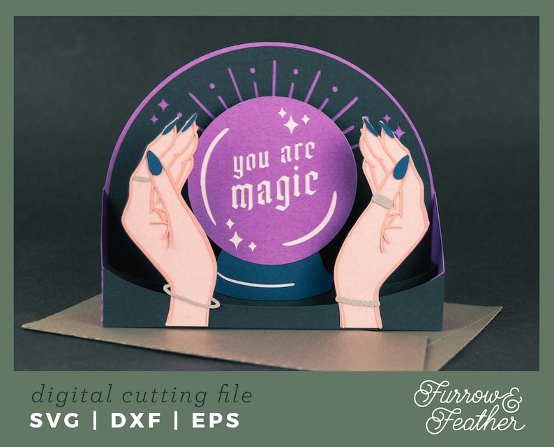 May include: A purple and black papercraft card with a pop-up crystal ball that reads "you are magic". The crystal ball is surrounded by two hands with painted nails.