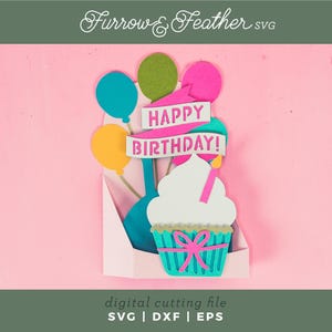 May include: A digital cutting file for a birthday card featuring a cupcake with a pink bow and a candle, surrounded by balloons and a banner that reads "Happy Birthday!"