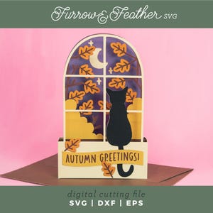 Puede incluir: Tarjeta de otoño de papel con la silueta de un gato negro mirando por una ventana una luna y follaje otoñal. La tarjeta dice "AUTUMN GREETINGS!" y es un archivo de corte digital.