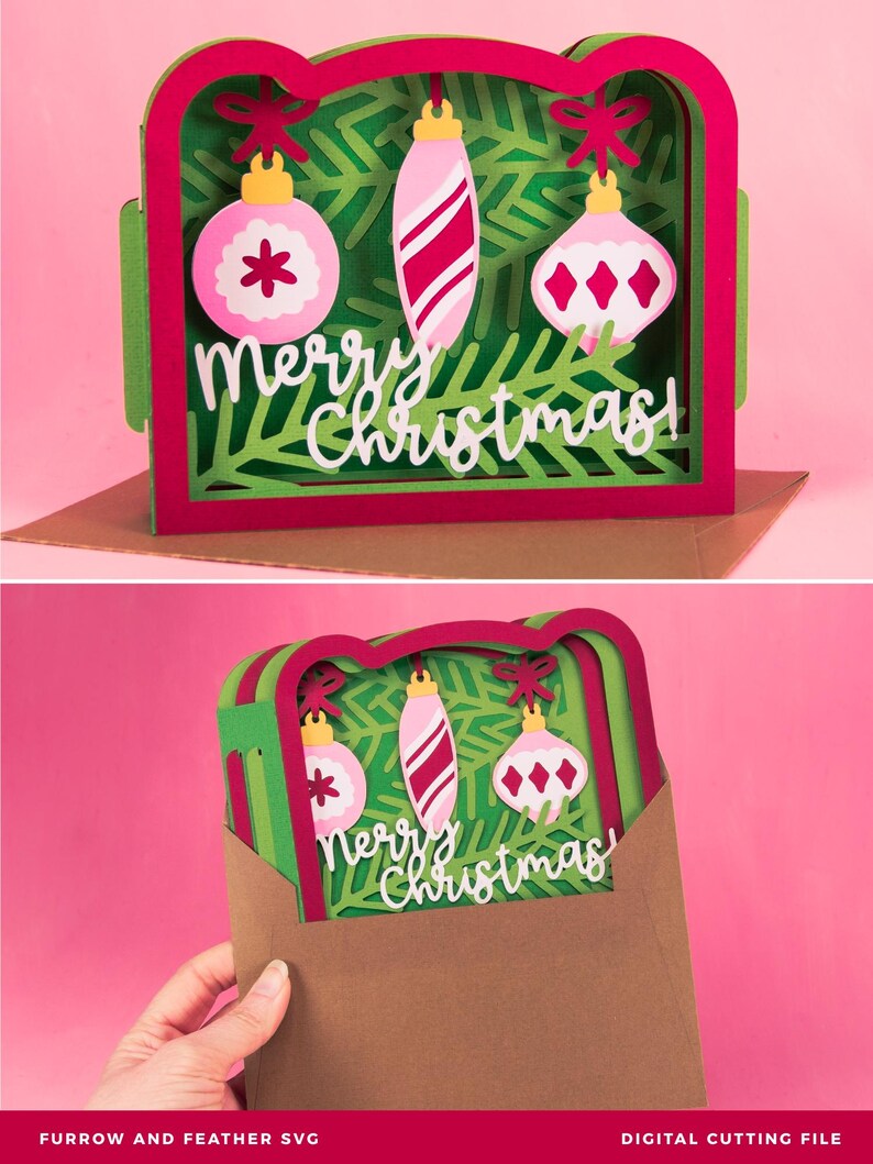 May include: A layered paper Christmas card with a green and red frame, featuring three hanging ornaments and the words "Merry Christmas." The ornaments are pink and white, with various designs. The card is displayed on a pink background.