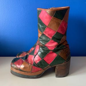 Peut inclure: Bottes à plateforme vintage avec un motif patchwork dans les tons marron, rouge, vert et rose. Les bottes ont un talon en bois épais et une semelle plateforme épaisse, mettant en valeur une esthétique rétro.