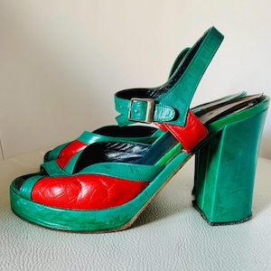 Peut inclure: Une paire de sandales à plateforme vertes et rouges avec un talon épais. Les sandales ont une bride à la cheville et un bout ouvert.