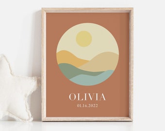 May include: A framed print with a minimalist landscape design in a circle. The landscape features a yellow sun, brown hills, green grass, and blue water. The print has a brown background and the name "Olivia" and the date "01.14.2022" are printed below the circle.