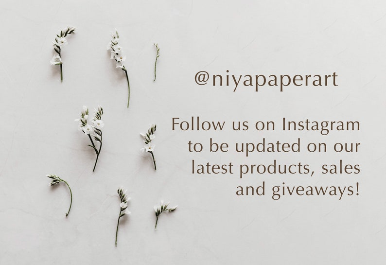 May include: White flowers with green stems arranged on a white background. The text '@niyapaperart' is displayed below the flowers. The text 'Follow us on Instagram to be updated on our latest products, sales and giveaways!' is displayed below the '@niyapaperart' text.