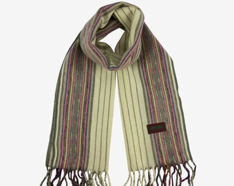 May include: Cream-colored scarf with vertical stripes in pink, yellow, gray, and purple. The scarf has a fringed edge and a small rectangular tag with text. A stylish accessory for any wardrobe.