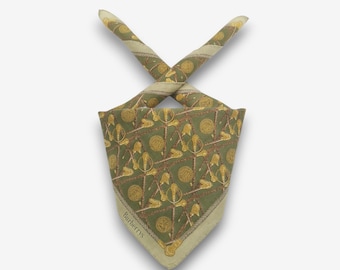 May include: A green and gold patterned scarf with a repeating design of swords and medallions. The scarf has a light green border and the word "Burberrys" is printed on the corner.