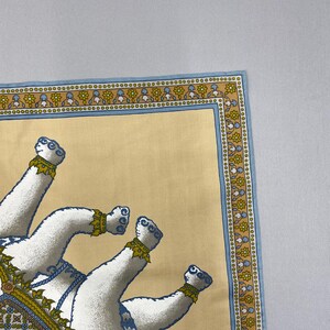 Puede incluir: Un pa&ntilde;uelo cuadrado de color crema con un dise&ntilde;o detallado. El pa&ntilde;uelo presenta un borde de patrones florales azules y dorados. El dise&ntilde;o principal incluye figuras de animales blancos con detalles en azul y dorado. El pa&ntilde;uelo tiene un borde azul claro.