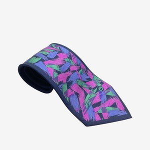 May include: A navy tie featuring a vibrant abstract design of brushstrokes in purple, pink, and green. The tie is folded, revealing the pattern and a small emblem. The tie's length is approximately 147 cm.