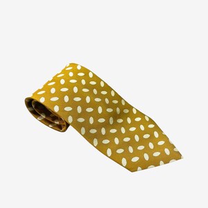 May include: Mustard yellow tie with a repeating pattern of white oval shapes. The tie is folded over, showing the underside of the fabric. The tie is a classic accessory for formal or business attire.
