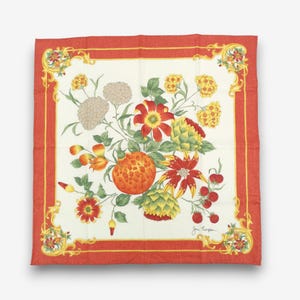 K&ouml;nnte beinhalten: Quadratisches Seidentuch mit floralem Design. Das Tuch hat eine cremefarbene Mitte mit einer lebendigen Anordnung von Blumen und Fr&uuml;chten in Rot-, Orange-, Gelb- und Gr&uuml;nt&ouml;nen. Ein roter Rand mit goldenen Akzenten umrahmt das Design.