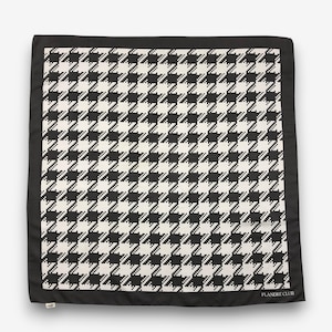 May include: Square black and white houndstooth pattern scarf with a black border. The scarf has a repeating pattern of black and white checks. The words "FLANDRE CLUB" are printed in white on the bottom right corner.