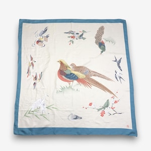 May include: A square silk scarf with a cream-coloured centre and a blue border. The design features a central pair of pheasants surrounded by various birds, including a crane, swallows, and a peacock, interspersed with floral branches and foliage.