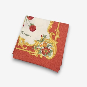 K&ouml;nnte beinhalten: Gefalteter quadratischer Schal mit cremefarbenem Mittelteil mit roten Erdbeeren und floralen Designs. Der Rand ist ein strukturiertes Rot mit goldenen Verzierungen. Der Name "Thompson" ist kursiv geschrieben.