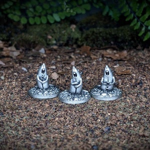 Może przedstawiać: Trzy srebrne miniaturowe figurki myszy śpiewających w chórze. Każda mysz stoi na okrągłej podstawie.