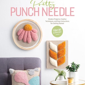May include: A book cover titled Pretty PUNCH NEEDLE Modern Projects, Creative Techniques, and Easy Instructions for Getting Started. It features a round framed pink and yellow flower punch needle art and a rectangular orange and white piece.
