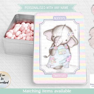 May include: A personalised metal tin featuring an elephant illustration. The tin has pastel stripes and the text "Nanny's Sweeties". The open tin reveals pink sweets.