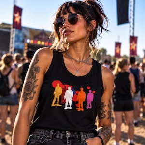 May include: A black vest top featuring a graphic print of five stylised human silhouettes in yellow, red, white, orange, and pink, set against a black background. The vest top has a scoop neckline and is worn with dark denim shorts.