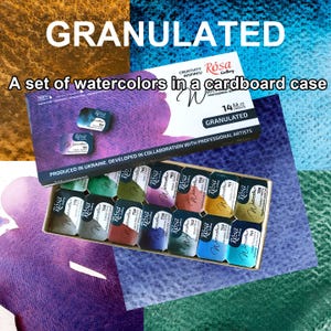 Puede incluir: Un juego de 14 acuarelas en una caja de cartón. La caja está etiquetada como "Granulated" y "Rosa Gallery". Los colores incluyen tonos de verde, azul, morado y dorado. También es visible el texto "Produced in Ukraine".