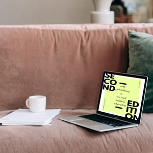 May include: A laptop computer with a light pink background. The laptop screen displays a checklist titled "Second Edition: Self-Publishing a Second Edition Checklist".